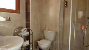 Un baño con lavamanos, inodoro y ducha.
