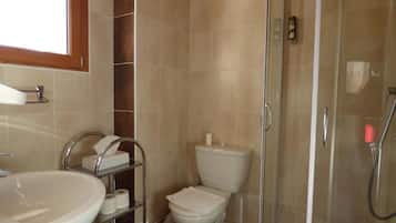 A bathroom with a sink, toilet, and shower.