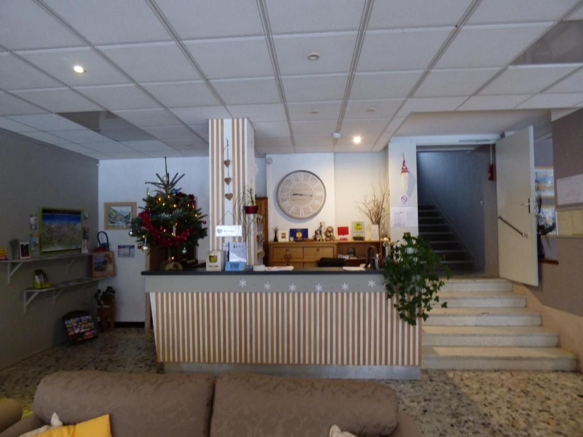 A reception area with a counter, a clock, a staircase, and a Christmas tree.