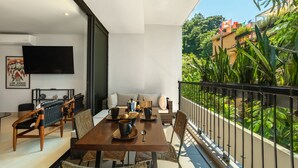 Ein Essbereich mit Holztisch, Stühlen und einem an der Wand befestigten Fernseher.