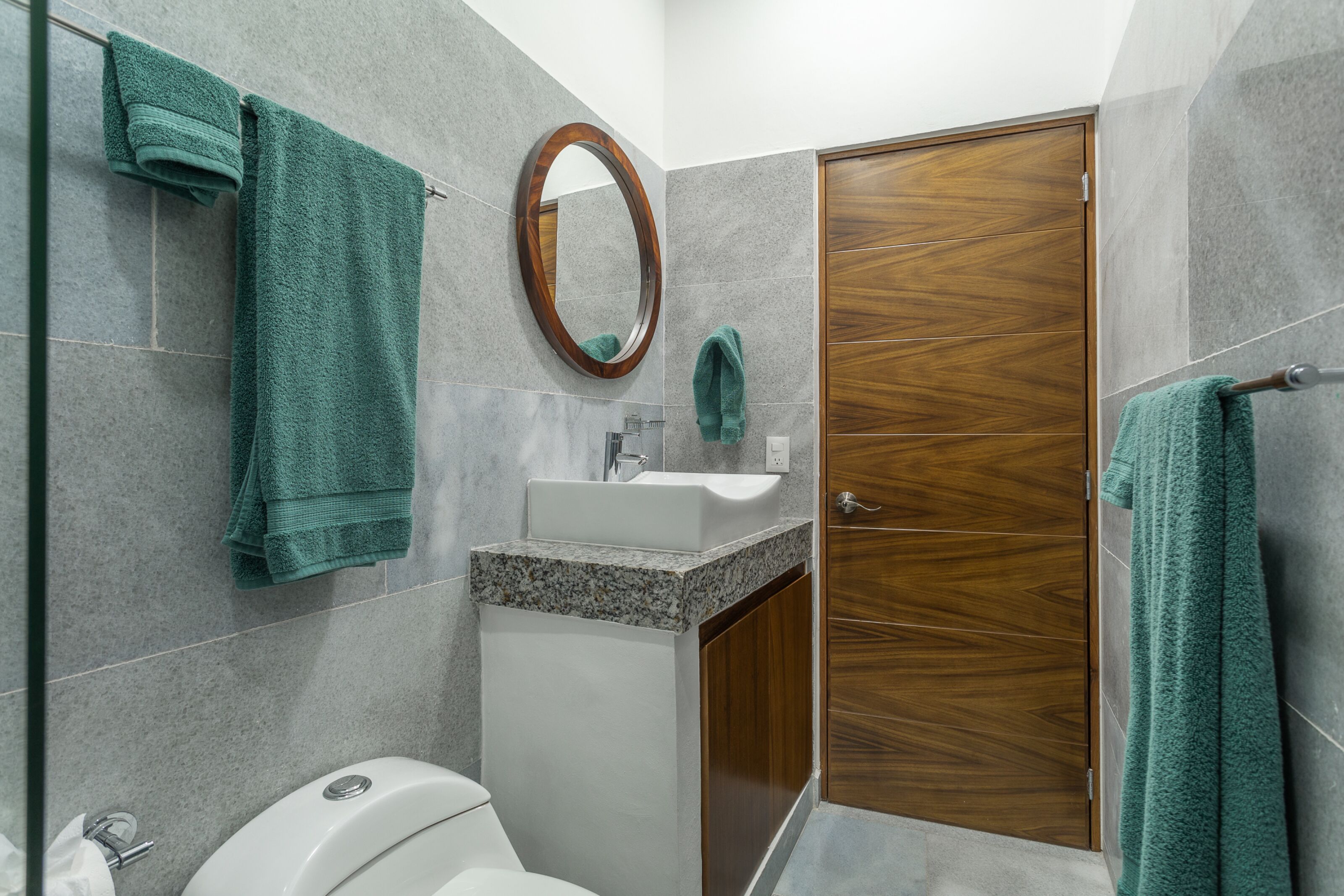 A bathroom with a sink, mirror, and wooden door.