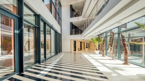 A modern hotel lobby with a checkered marble floor, large glass windows, and contemporary art sculptures. - Azalai Hôtel Dakar (Dakar)