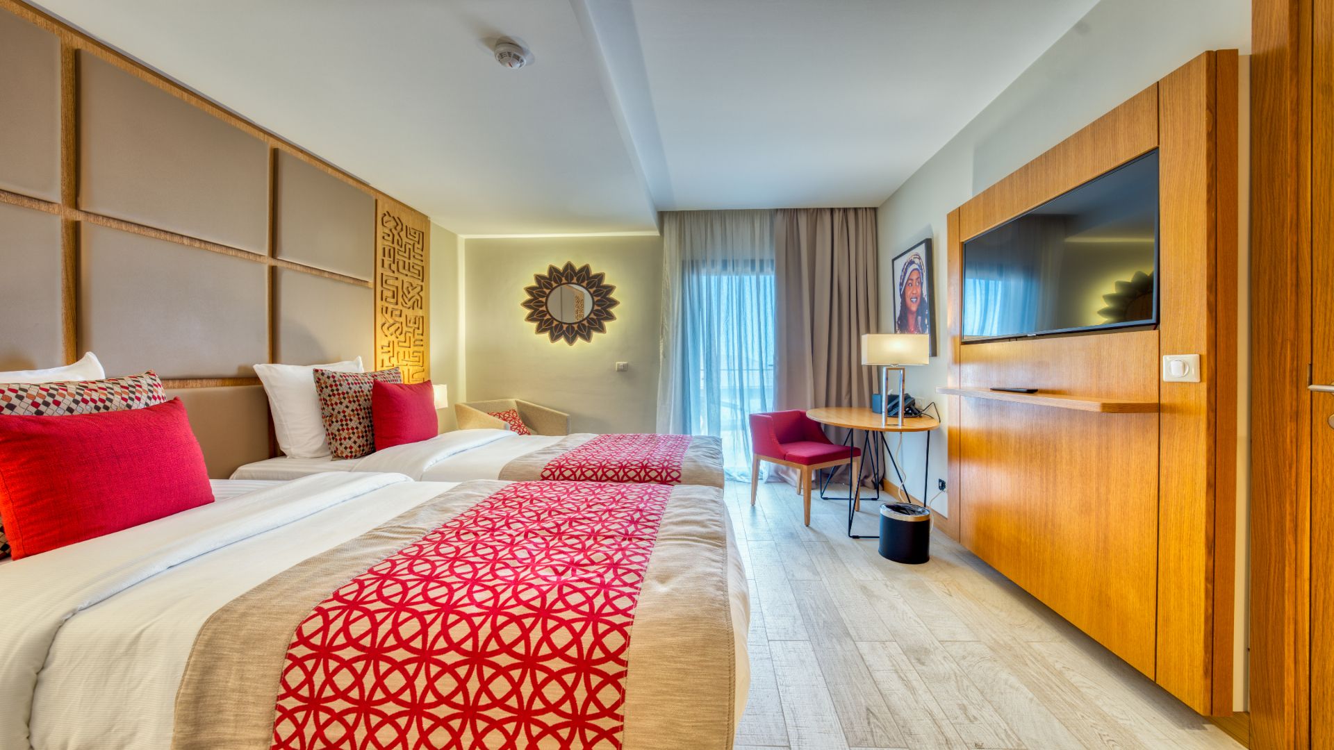 A hotel room with two beds, a TV, a desk, and a wardrobe.