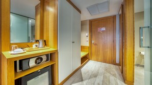 A hotel room with a wooden vanity, a mirror, a coffee maker, and a microwave. - Azalai Hôtel Dakar (Dakar)