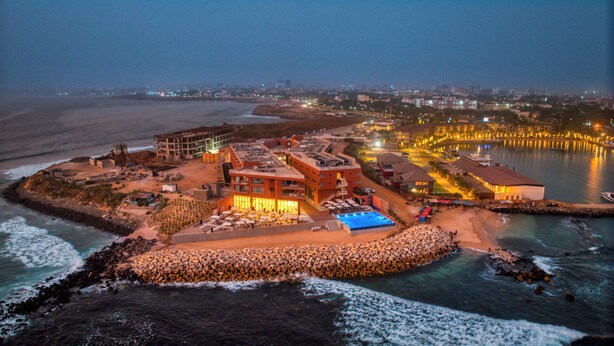 An aerial view of a coastal hotel with multiple buildings, a swimming pool, and a beach area. - Azalai Hôtel Dakar (Dakar)
