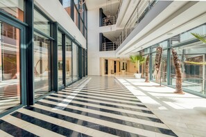 A modern hotel lobby with a checkered marble floor, large glass windows, and contemporary art sculptures. - Azalai Hôtel Dakar (Dakar)