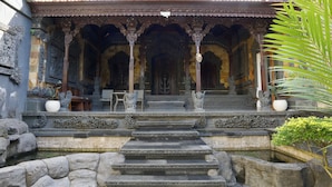 Un bâtiment traditionnel doté de détails architecturaux raffinés, notamment un toit recouvert de tuiles et des colonnes décoratives.