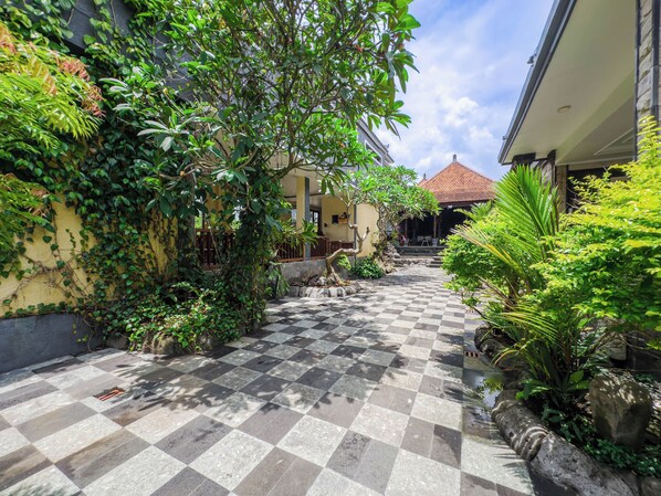 Escape to a serene courtyard surrounded by lush greenery and traditional architecture.