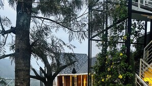 A building with a stone facade, a staircase, and a view of the surrounding area. - Kanavu Valley View Resort (Coonoor)