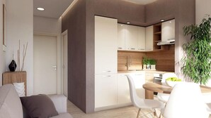 Una cocina moderna con armarios blancos, encimera de madera y un comedor con mesa y sillas blancas.