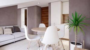 Een moderne woonkamer met een bank, witte stoelen, een ronde tafel en een plant in pot.