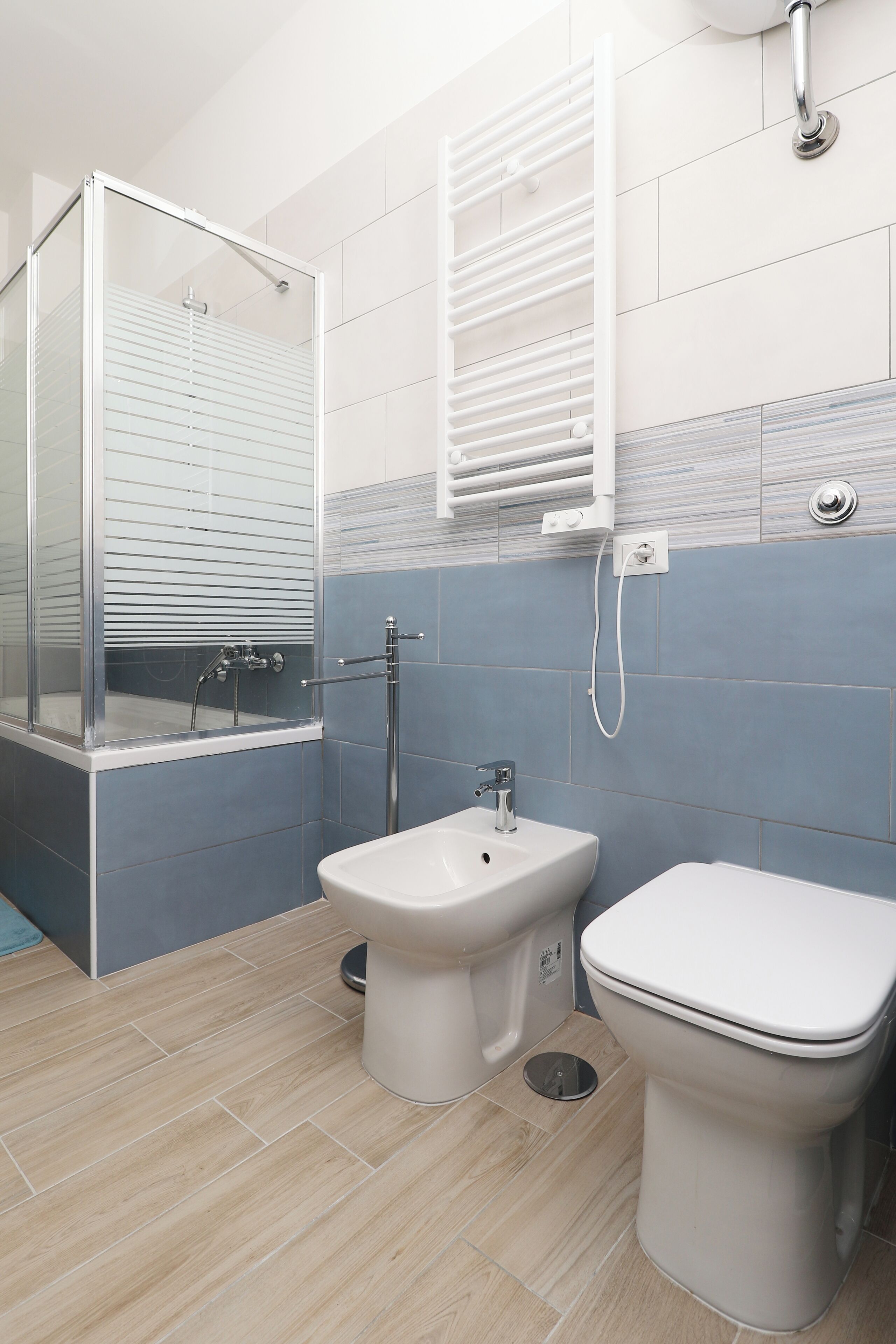 Ein modernes Badezimmer mit Duschkabine, Standwaschbecken und Toilette.