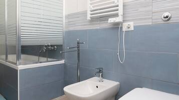 Ein modernes Badezimmer mit Duschkabine, Standwaschbecken und Toilette.