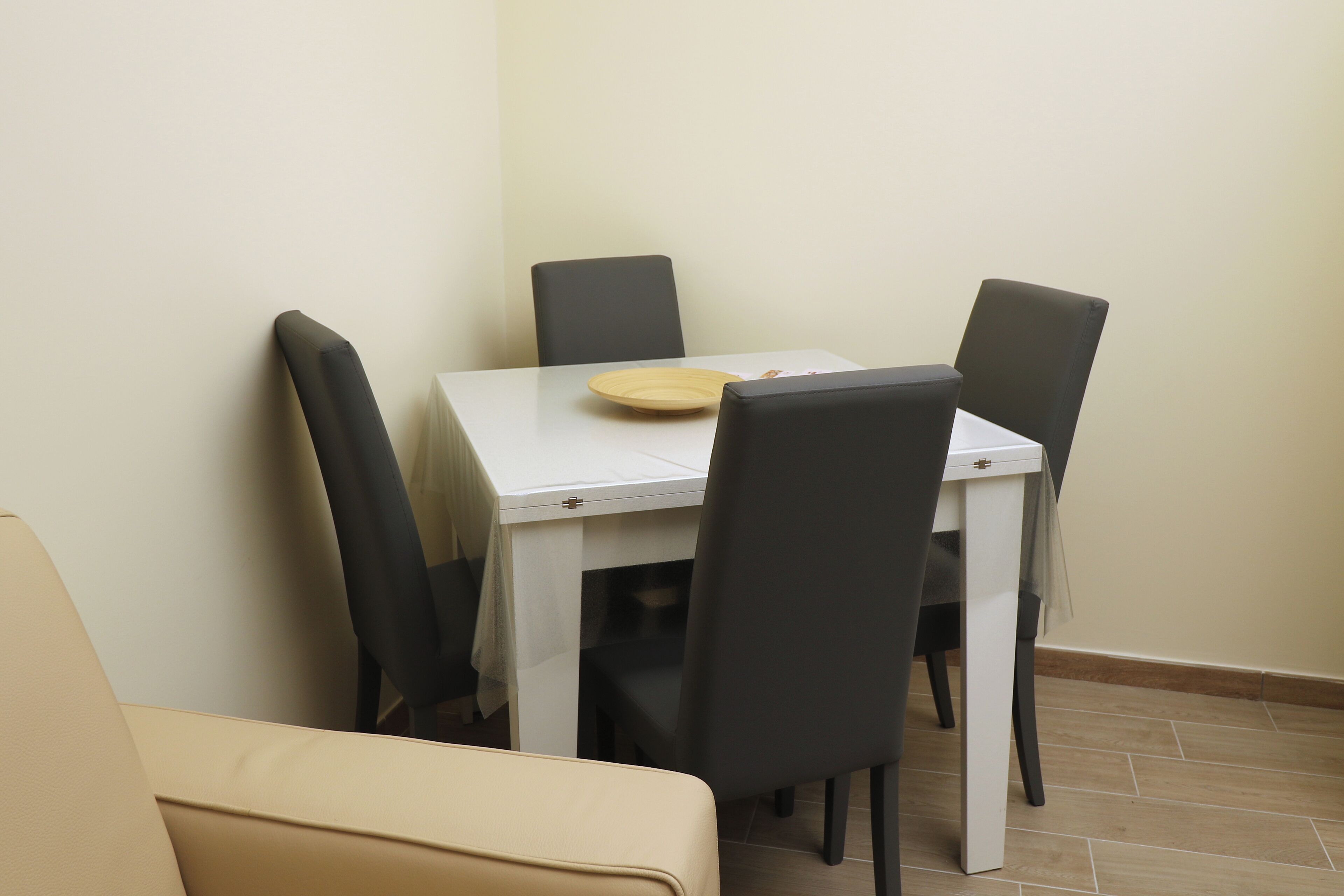 A dining area with a white table and four black chairs.