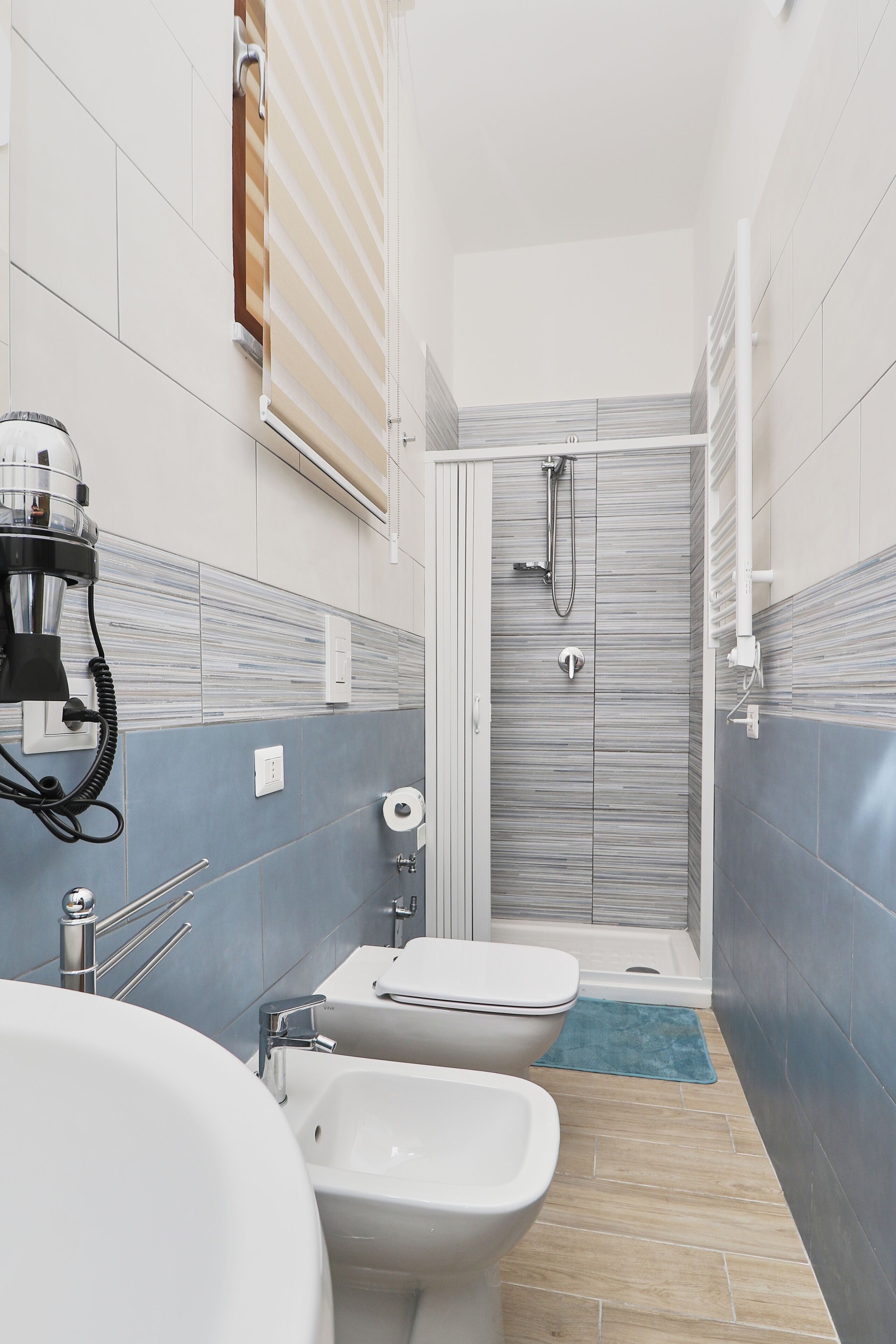 Une salle de bain équipée d’une douche, de toilettes, d’un bidet et d’un lavabo.