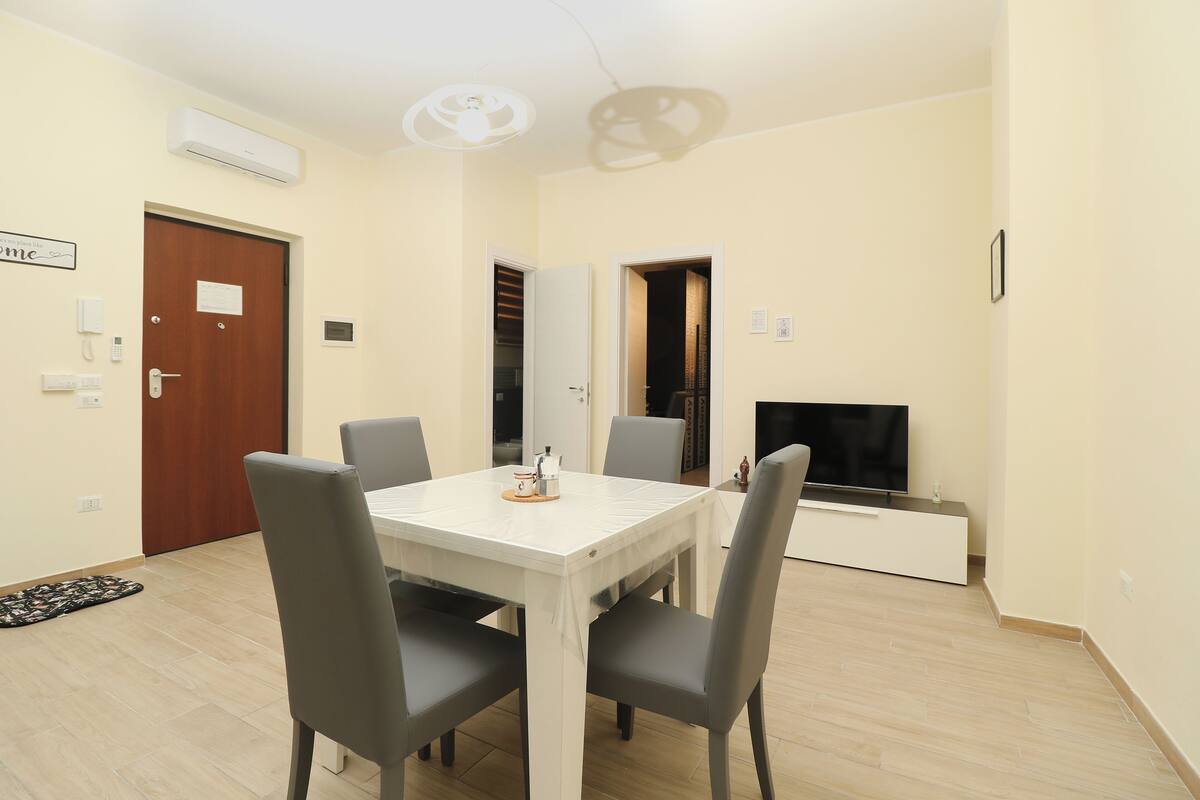 A dining area with a table, chairs, and a TV.
