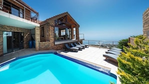 Una casa moderna con piscina, balcón y vista al océano.