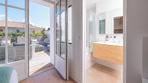 A modern bathroom with a glass shower, a wooden vanity, and a large mirror.