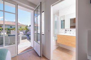 Enjoy a spacious room with a sliding glass door leading to an outdoor area featuring a deck with seating and a view.