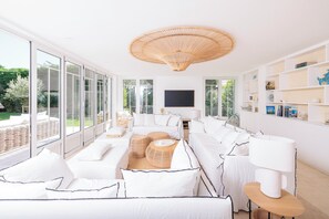 Relax in this spacious living room with a large sofa, wicker side tables, and a floor lamp.