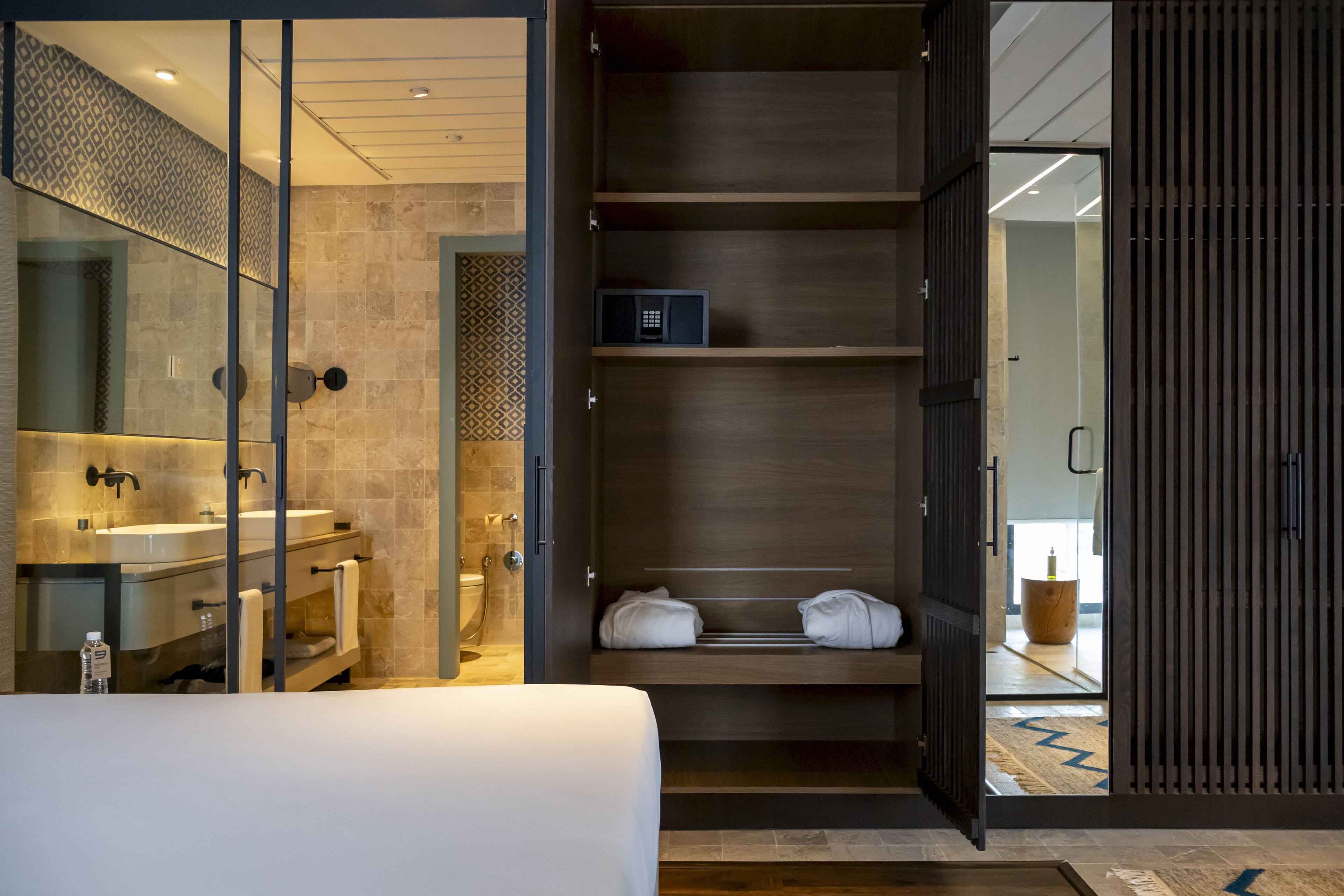 A modern bathroom with a glass-enclosed shower, a sink, and a towel rack.