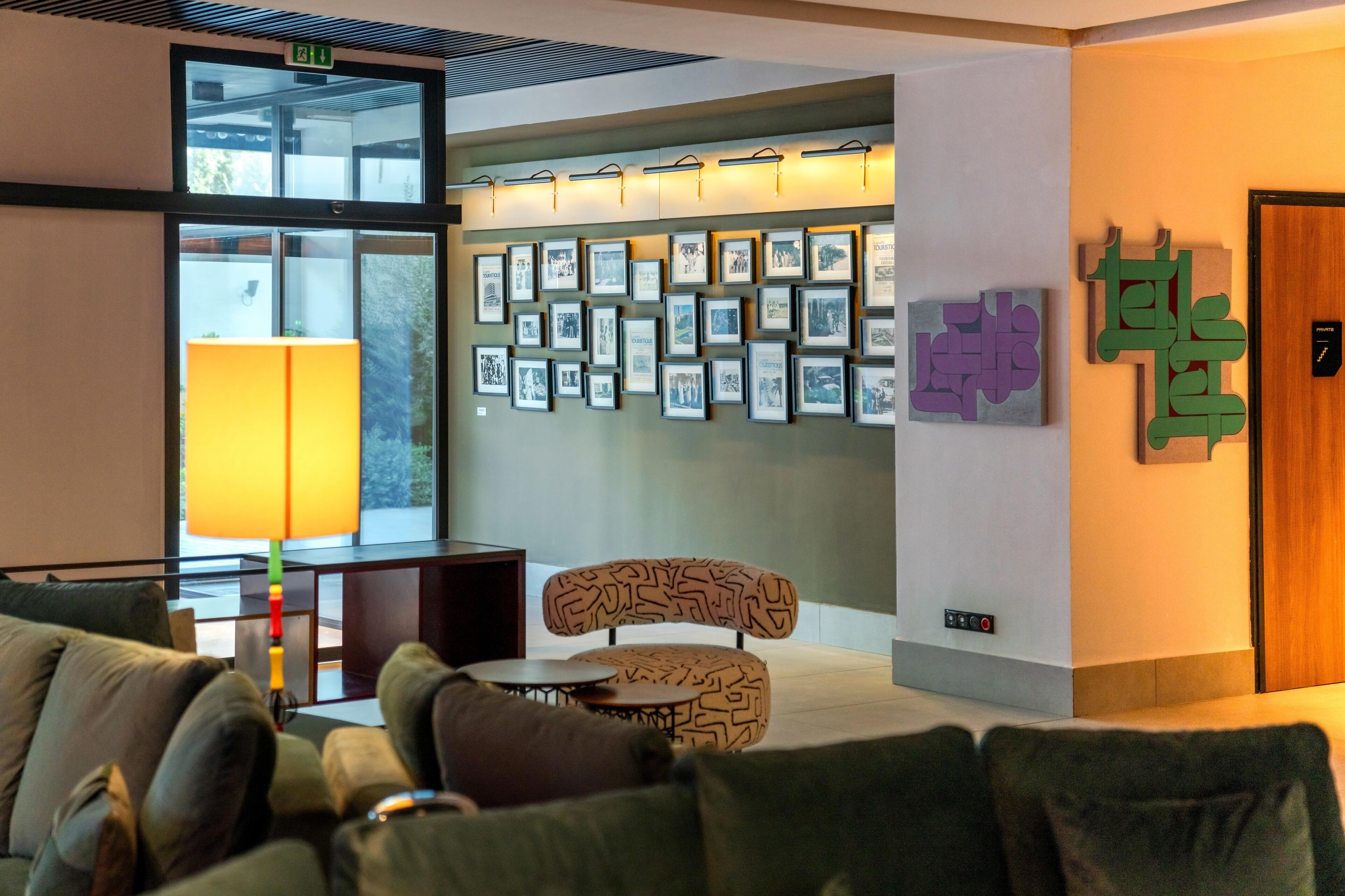A modern lobby with a sofa, a table, and a wall adorned with framed pictures.