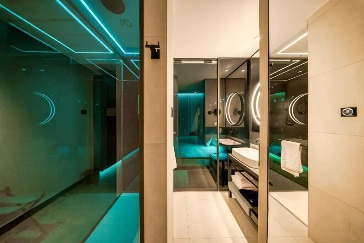 Ein modernes Badezimmer mit Glasabtrennung, Waschbecken und Spiegel.