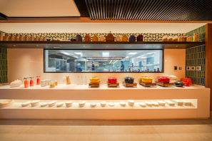 Una barra de buffet con diversos alimentos y utensilios.