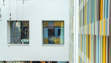 A modern interior with hanging light fixtures, a patterned window, and a vertical striped wall.