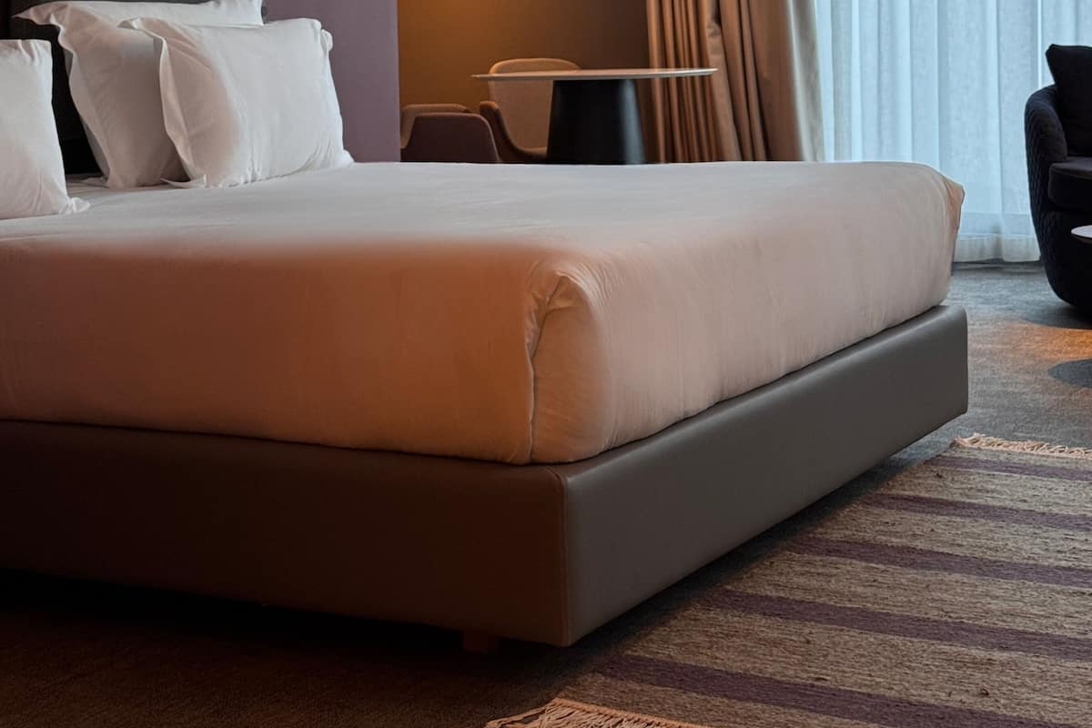 Ein modernes Hotelzimmer mit einem großen Bett, einem Schreibtisch und einem Sessel.