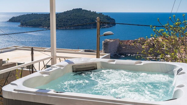 Un jacuzzi con vistas al mar y a una pequeña isla.