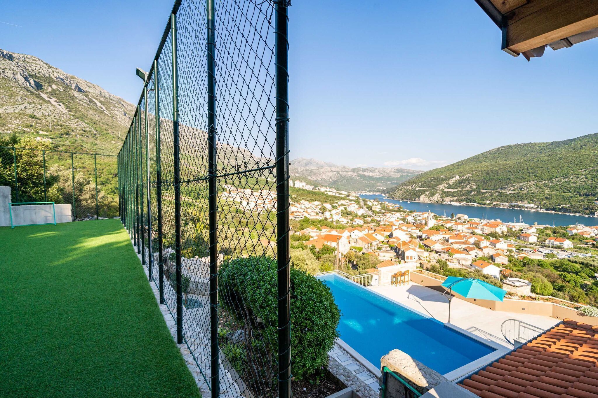 A swimming pool with a view of a coastal town and mountains.