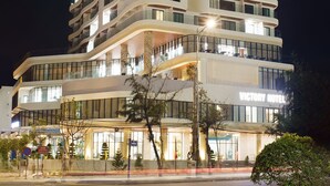 Un hotel de varios pisos con balcones y un letrero que dice 'Factory Hotel'.