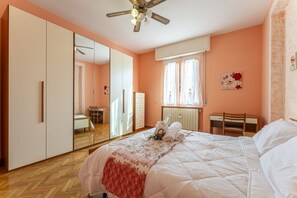 A bedroom with a large bed, a wardrobe, a desk, and a ceiling fan. - Leandro's House (Montecatini Terme)
