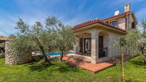 A stone house with a red-tiled roof, a swimming pool, and a stone wall. - Holiday House Casa D Oro (Malinska-Dubasnica)