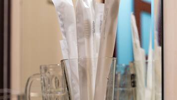 A glass shelf with a tissue dispenser and a glass mug.