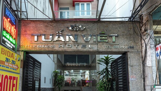 Een hotelentree met een bord waarop 'HOTEL TUAN VIET' staat.