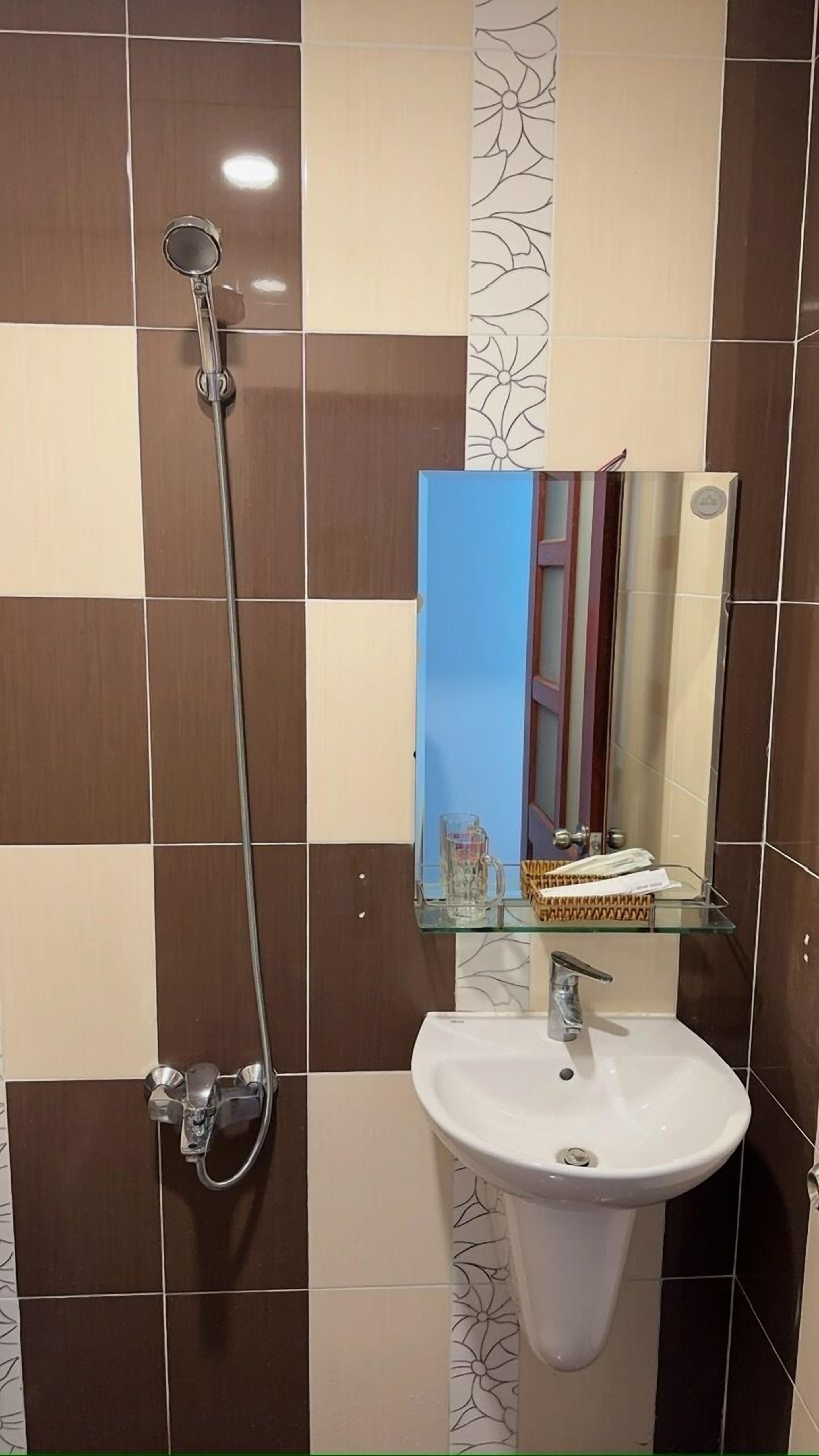 Un baño con cabina de ducha de vidrio, un lavamanos blanco y un espejo.