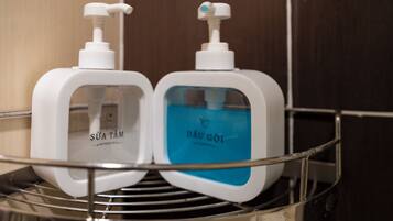 Two toiletry bottles on a metal shelf in a bathroom.