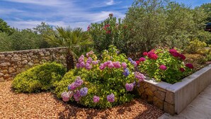 A garden with various plants and a stone wall. - Villa Gita in Malinska (Malinska-Dubasnica)