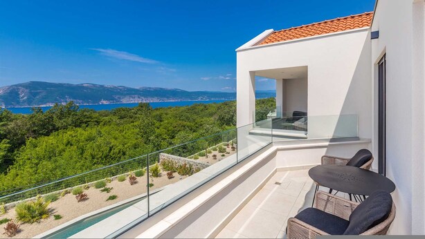 A balcony with a glass railing overlooking a pool and a scenic view of mountains and the sea. - Villa Verena With Heated Pool (Krk)