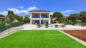 A two-story house with a swimming pool, a well-maintained lawn, and a fenced yard. - Villa Magnifica in Pinezici (Krk)
