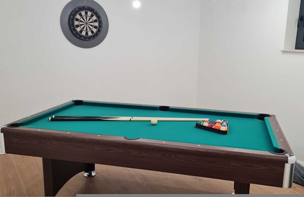 Una mesa de billar con dardos y bolas de billar.
