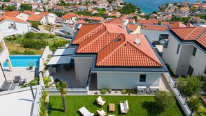 A residential area with modern houses, a swimming pool, and a well-maintained garden. - Villa Majestic With Sauna and Beautiful Views (Vrbnik)