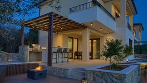 A modern house with a covered patio, outdoor seating, and a barbecue area. - Villa Lady With Heated Pool Jacuzzi and Sauna (Krk)