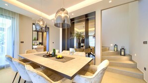 A modern dining area with a large table, comfortable chairs, and pendant lighting. - Villa Lady With Heated Pool Jacuzzi and Sauna (Krk)