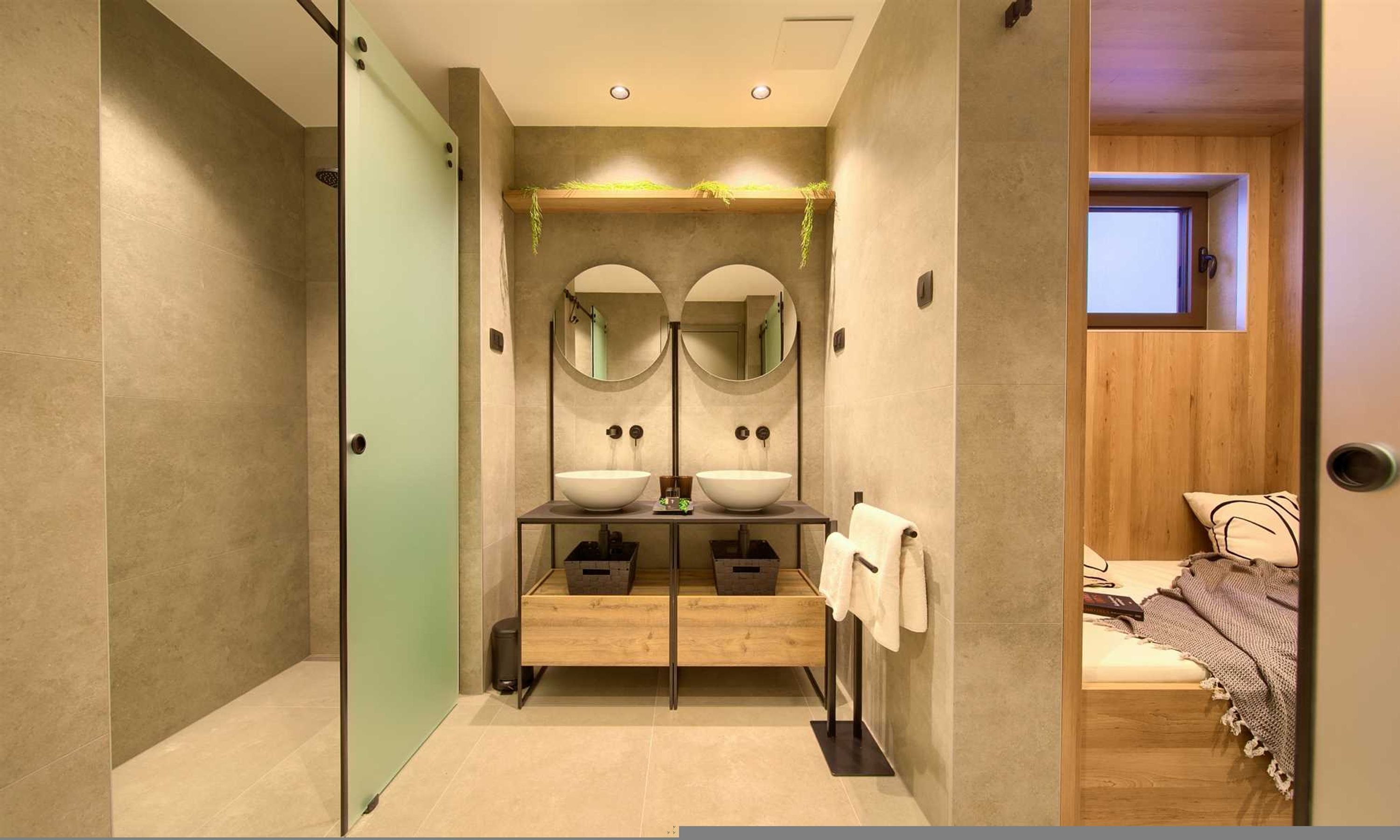 Une salle de bain moderne avec une douche à l’italienne en verre, deux vasques et un meuble-lavabo en bois.