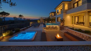 A modern two-story house with a swimming pool, outdoor seating, and a hot tub. - Villa Lord With Heated Pool Jacuzzi and Sauna (Krk)