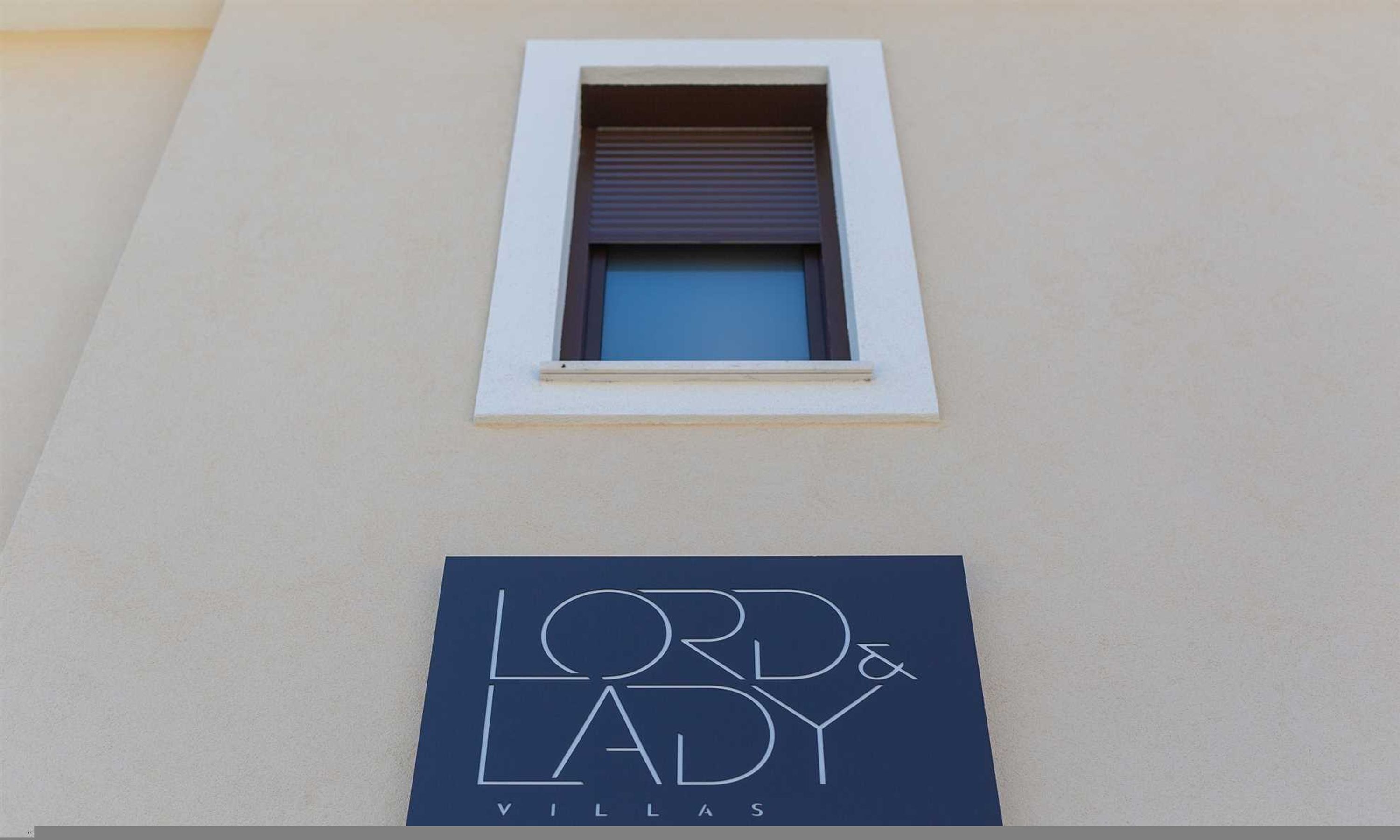 A building facade with a window and a sign that reads "Lord & Lady Villas".