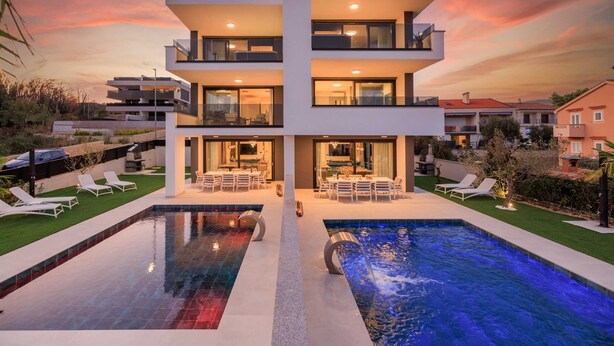 A modern multi-story house with a swimming pool, outdoor seating, and a well-maintained garden. - Villa LEA Magdalena III (Krk)